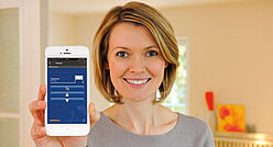 Frau mit Smartphone mit geöffneter Smart-Home App
