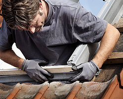 Handwerker beim Einbau eines Dachfensters